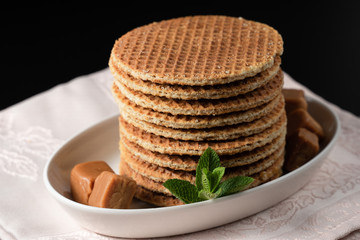 Closeup several stacked stroopwafels or dutch waffles made from caramel syrup, delicate decoration...