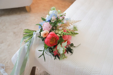 Beautiful wedding bouquet of peonies with ribbons.