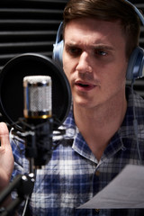 Male Voiceover Artist In Recording Studio Talking Into Microphone