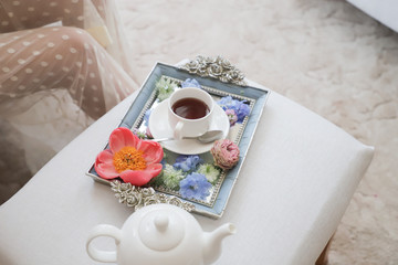 A beautiful white Cup of tea on a gold tray.Morning of the bride.