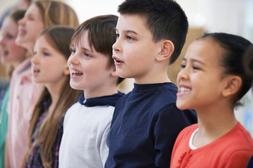 Group Of School Children Singing In Choir At Stage School Together