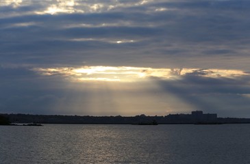 Sunbeam looking through the cloudy sky onto the water