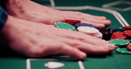 Close up of gambler pushing his chips all in the middle of the poker table shot in 4k super slow motion