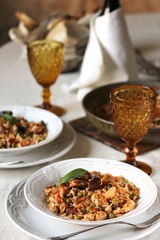 paella from orzo pasta with mussels, seashells and chicken. Seafood paella, traditional spanish dish. Paella on rustic black wooden table. Top view