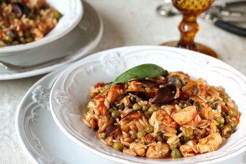 paella from orzo pasta with mussels, seashells and chicken. Seafood paella, traditional spanish dish. Paella on rustic black wooden table. Top view