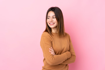 Obraz premium Young woman over isolated pink background with arms crossed and happy