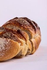 Pokrojony bochenek chleba na białym tle.
