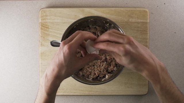 Cracking white egg into bowl of ingredients for meal