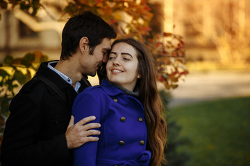 guy with a girl hug and kiss. Autumn in the park. happy day