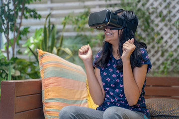 Indian Asian girl viewing through a Virtual Reality device, experiencing immersive technology