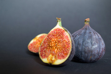Fresh ripe figs on dark table. Healthy mediterranean fig fruit. Fresh figs on black background.