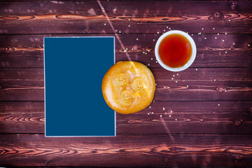 Traditional tandyr bread of Central Asia with tea on a wooden background with place for text. Top view