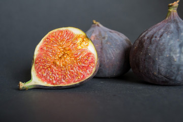 Fresh ripe figs on dark table. Healthy mediterranean fig fruit. Fresh figs on black background.