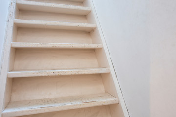 Basic white wooden stairs with white wall modern design, needs renovation close-up