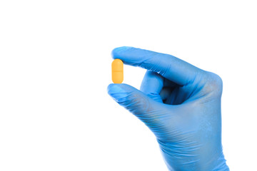 Doctor hand in sterile gloves holding yellow pill isolated on white background  close up view  - Image