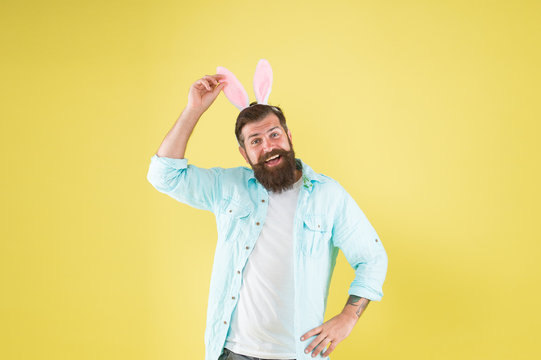 Touch my ears. Man long rabbit ears. Happy bearded man Easter rabbit costume. Easter bunny or hare. Hipster dressed for Easter party. Easter bunny symbol of fertility and spring. Having fun