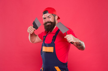 I love my job. Repairman in uniform ready for job. serious builder use spatula tool. building and construction. bearded worker hold repair equipment. carpenter working with confident look