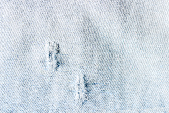 Denim texture. Texture of ripped light blue jeans.