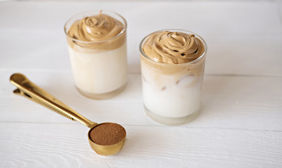 Iced frothy Dalgona Coffee, a trendy fluffy creamy whipped coffee. Korean drink latte espresso with coffee foam. cups and spoon with instant coffee and sugar. 