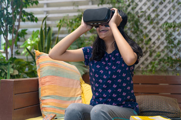 Indian Asian girl viewing through a Virtual Reality device, experiencing immersive technology