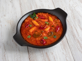 Mixed vegetable Goan curry on a wooden table, Indian food