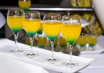 Barman show. Four alcoholic cocktails at the bar on a white porcelain plate