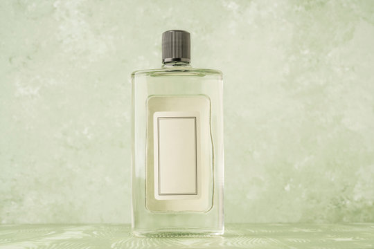 bottle of cologne with empty label over green