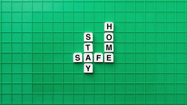 Stay Home, Stay Safe concept with Scrabble tile, Top View. Stop Motion