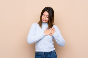 Young woman over isolated background having a pain in the heart