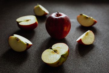 Cut apples on grey background, back natural light