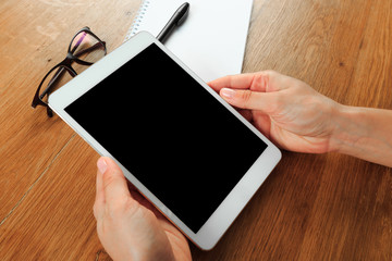 female hands holding smart phone on wooden background  , place for your text  .