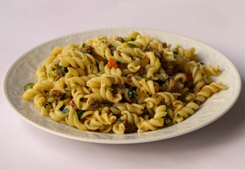 Turkish style ground beef, tomato, onion and parsley pasta in a white plate.
