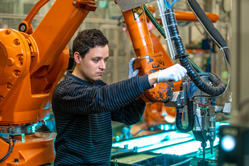 robotization of modern industry in the factory. Introduction of new robotic arms to replace human...