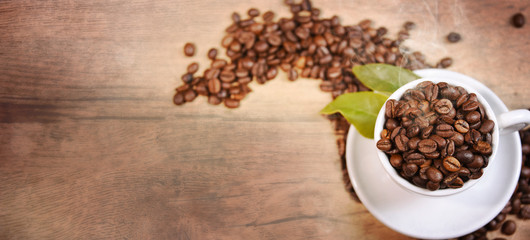 Coffee cup and beans on old kitchen table.