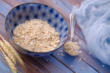 Rolled oats or oat flakes in wooden bowl on table