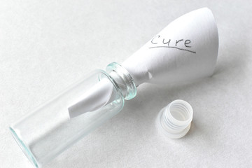 Glass flask with a stopper on a white background with a note medicine