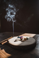 Incense palo santo stick with smoke used for energy purification in the morning. In combination with mineral stones serve great for therapy, meditation and yoga practice indoor. 