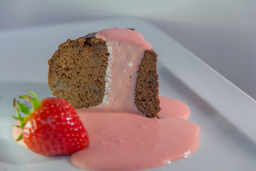 Close up a piece of chocolate cake with a strawberry cream. White background. homemade concept.