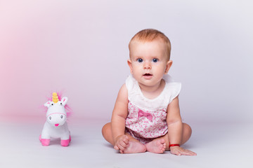 little girl sitting with stuffed unicorn