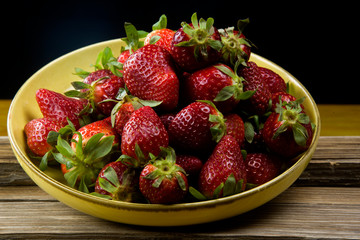 ripe stawberries on a yellow dish