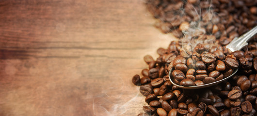 Coffee cup and beans on old kitchen table.