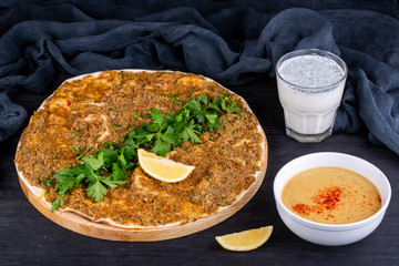 Meat pizza with meat mince, with parsley and lemon slice, served with puree soup and glass of kefir