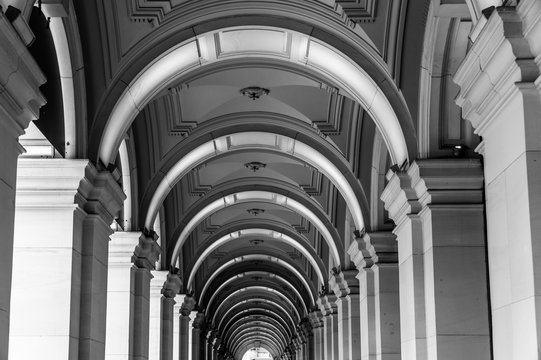 Long exterior portico of old Melbourne General Post Office Building with row of repeating illuminated arches