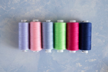 colorful bright skeins of thread on a soft blue background close up