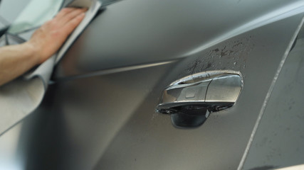 Close up of paint protection film installation on modern luxury car. PPF is polyurethane film that...