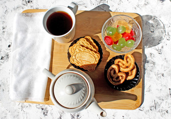 A cup of tea with cookies and sweets. Place to insert text. Breakfast or snack concept.