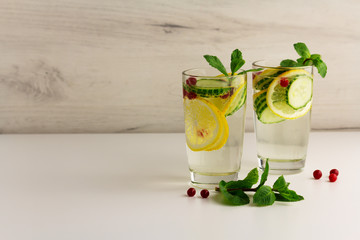 Sassy diet water. Cucumber, lemon, mint lemonade in glasses on light background