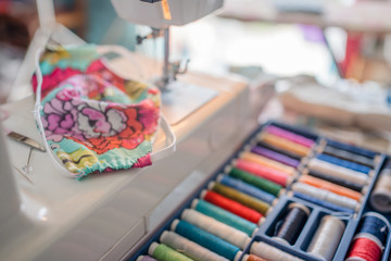 Closeup of hand tailor made protective face mask during sewing production. Pandemic pollution art and craft. Secure lifestyle COVID19.