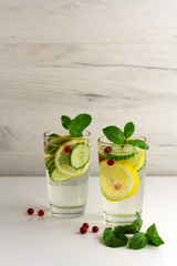 Sassy diet water. Cucumber, lemon, mint lemonade in glasses on light background