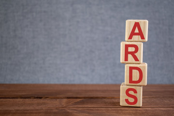 Abbreviation ARDS (Acute Respiratory Distress Syndrome) text acronym on wooden cubes on dark wooden backround. Medicine concept.